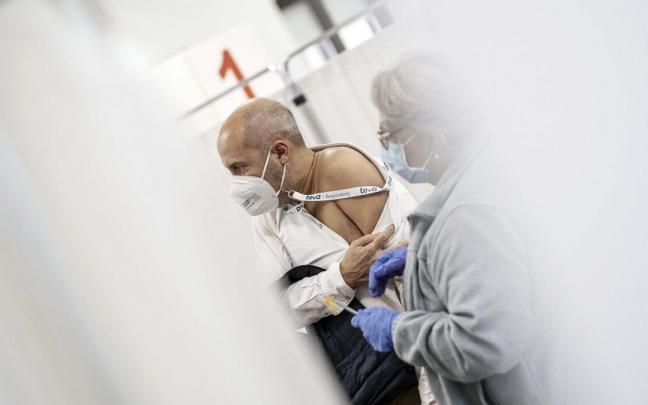 Una enfermera vacuna a un hombre.