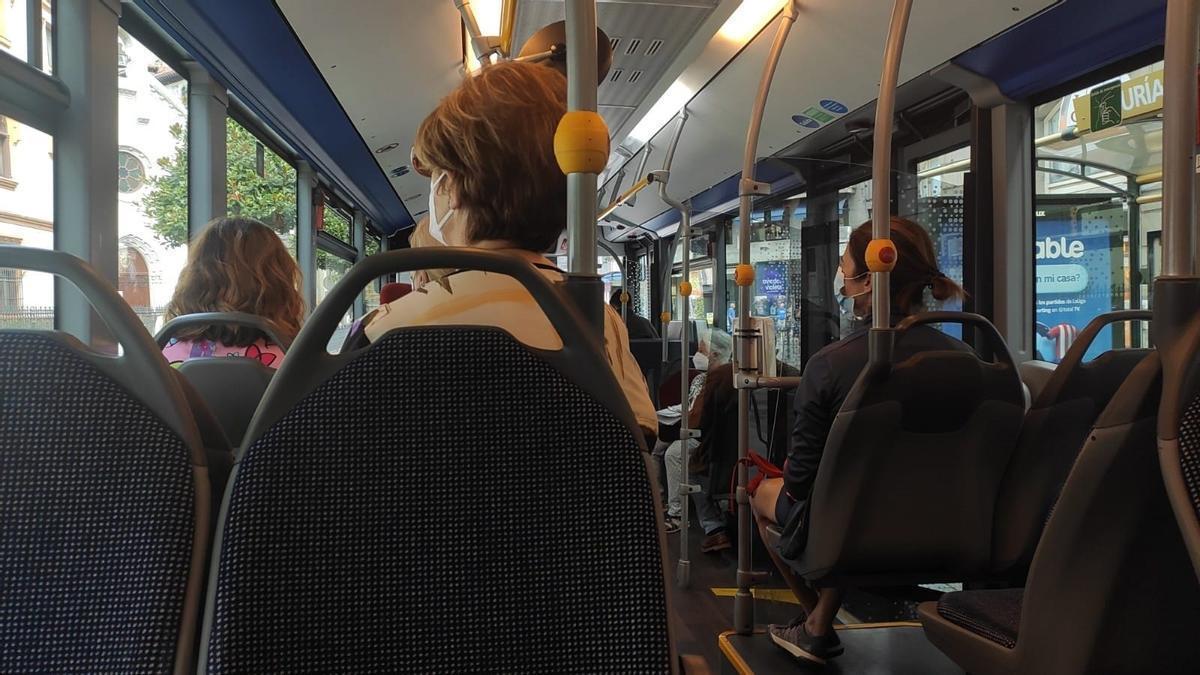 Varias personas con mascarilla en el interior de un autobús.