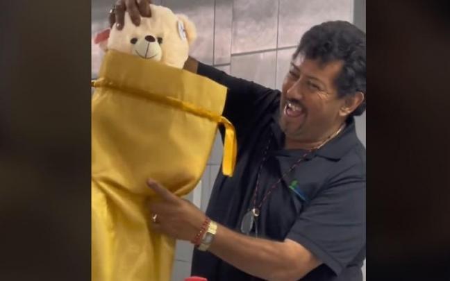 El hombre, feliz al recibir como regalo un oso de peluche.