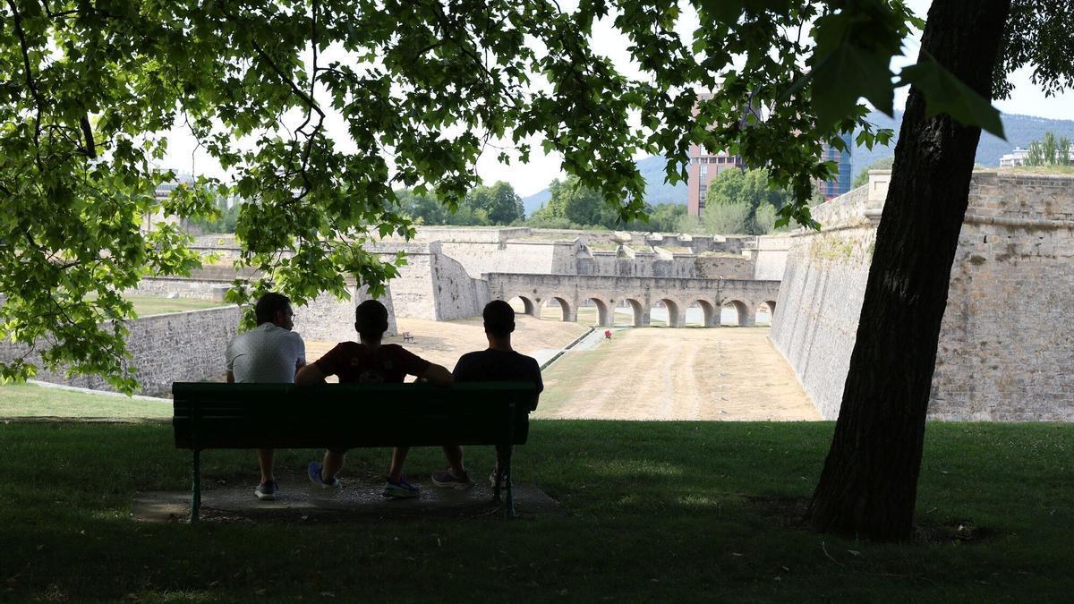 Jóvenes descansando en la Vuelta del Castillo en un día caluroso en Pamplona.