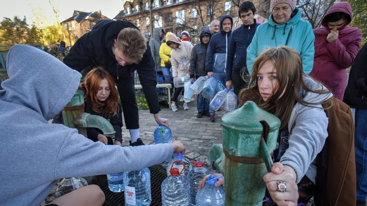 Un grupo de ciudadanos hacen cola en Kiev para llenar garrafas de agua.