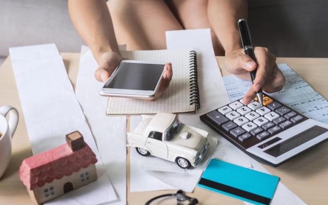 Una persona realiza cuantas en casa para cuadrar su presupuesto.