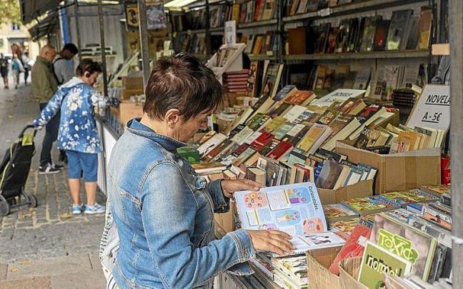 Un mujer ojea uno de los ejemplares en la feria.