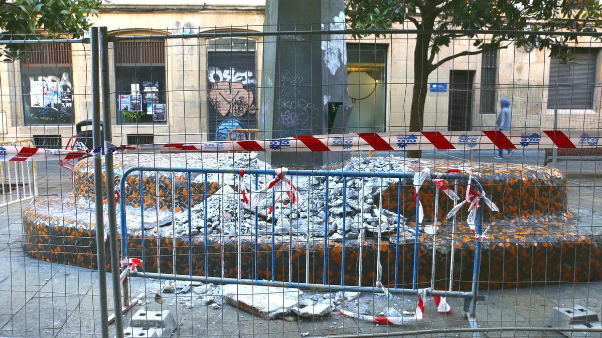 Banco alrededor de la farola central de la plaza, que está siendo destruido.