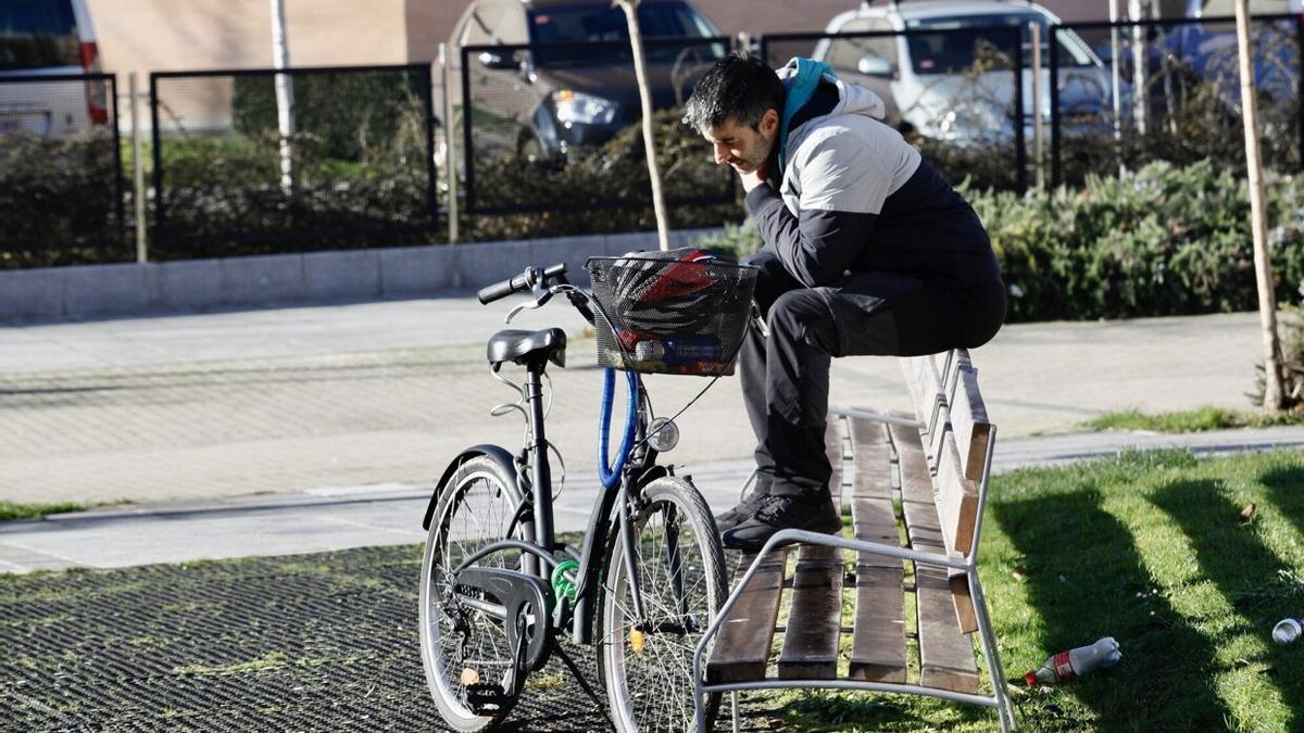 Joven, en un banco con la bici