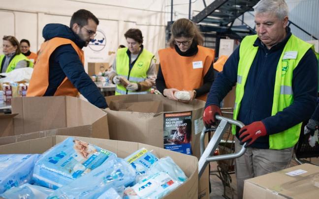 Un grupo de voluntarios almacena alimentos en cajas en la Fundación Banco de Alimentos. Un grupo de voluntarios almacena alimentos en cajas en la Fundación Banco de Alimentos.