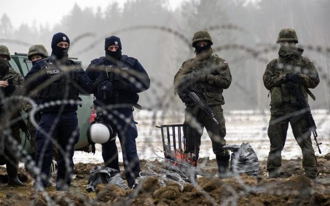 Fuerzas de seguridad de Polonia supervisan la construcci&oacute;n de barreras en la frontera con Bielorrusia.
