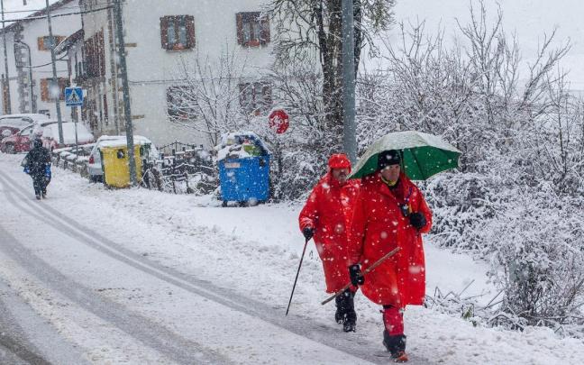 Tres peregrinos transitan por Erro bajo la nieve este lunes. Tres peregrinos transitan por Erro bajo la nieve este lunes.