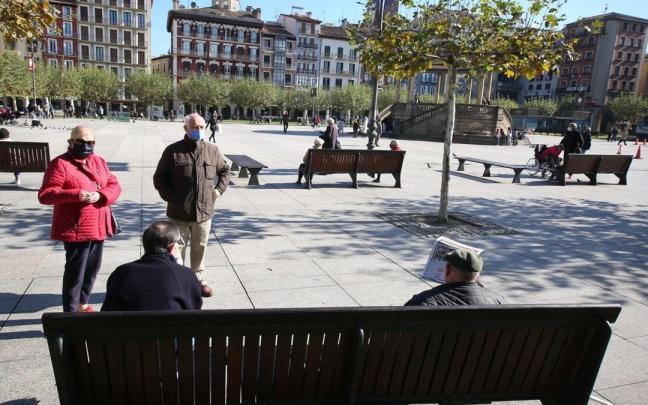 Imagen de archivo de personas mayores con mascarilla hablando en la Plaza del Castillo.