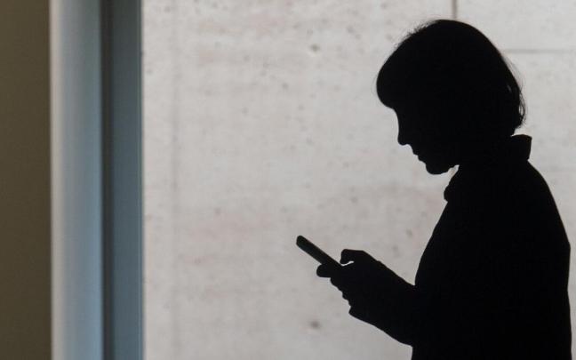 Una mujer revisa su teléfono móvil. Una mujer revisa su teléfono móvil.
