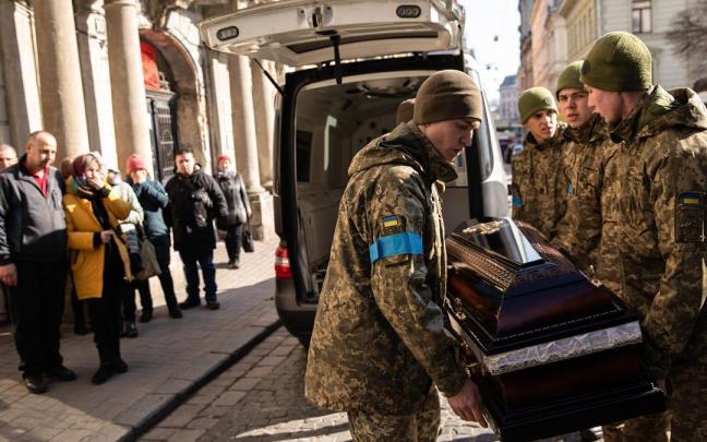 Varios soldados cargan el féretro de uno de los fallecidos en el ataque a la base militar de Leópolis.