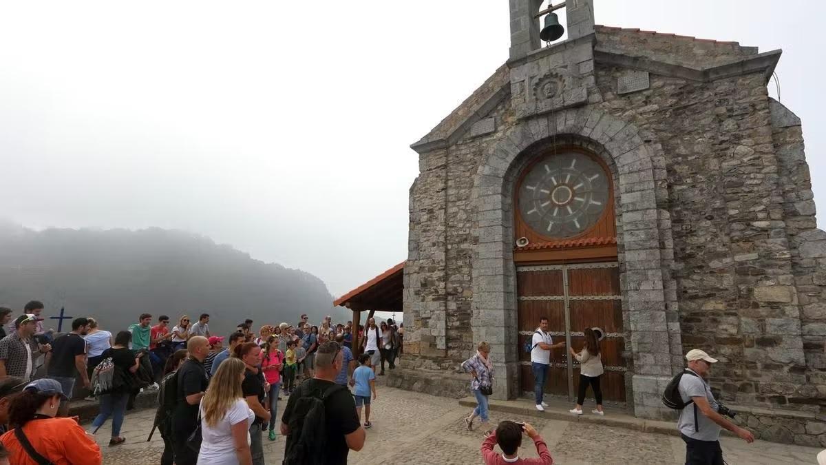 La iglesia y su campana, rodeados de turistas.