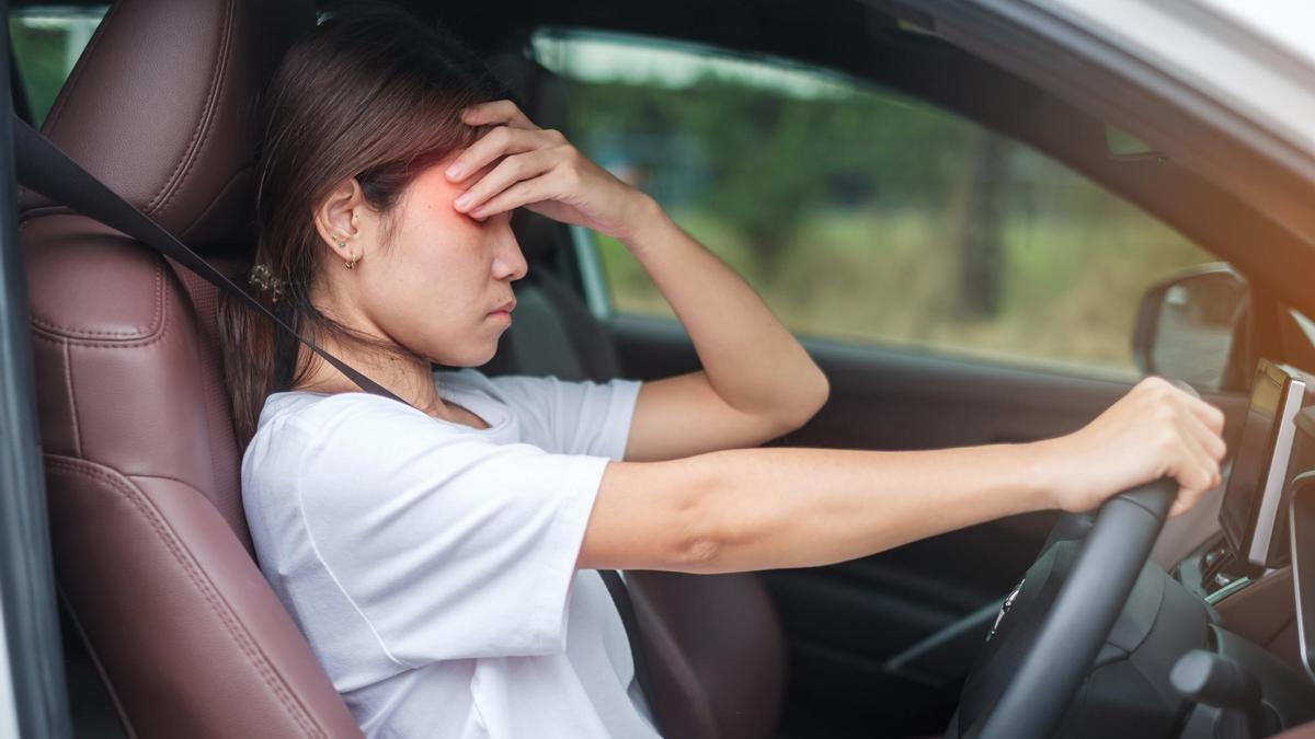 Una joven con resaca, al volante de su coche.