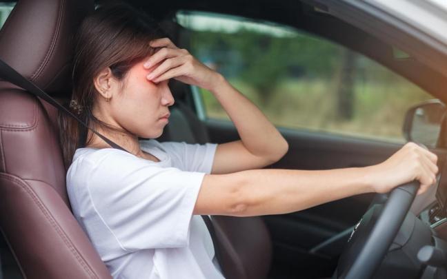 Una joven con resaca, al volante de su coche. Una joven con resaca, al volante de su coche.