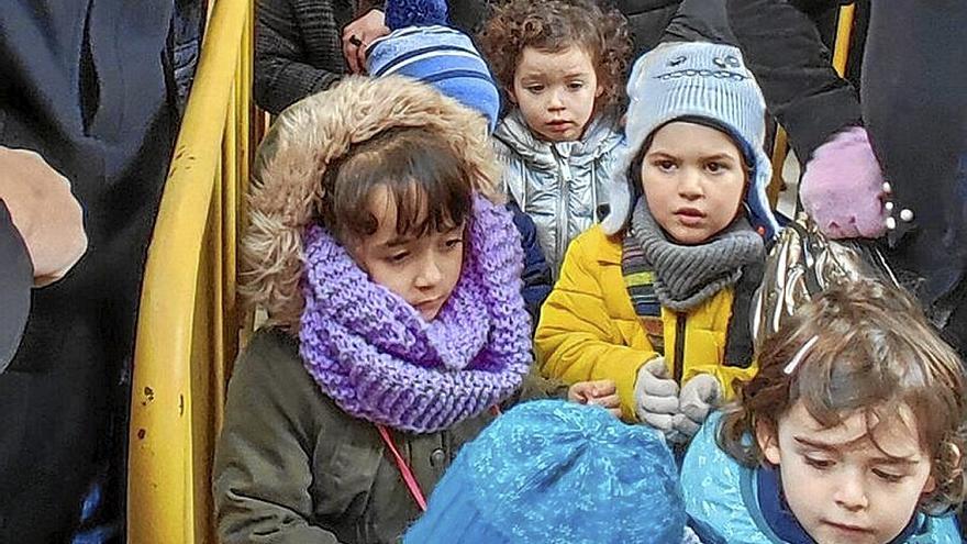 Los niños y niñas salen de la iglesia y reciben las monedas de Viana.