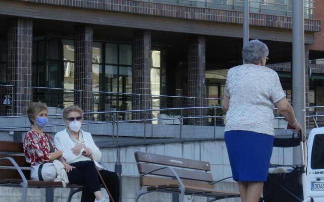 Varias ancianas pasean ante una residencia.