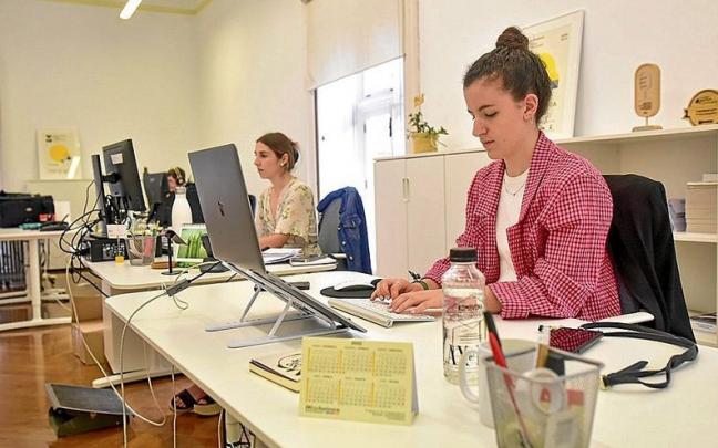 Dos mujeres j&oacute;venes desarrollando sus funciones en su puesto de trabajo.