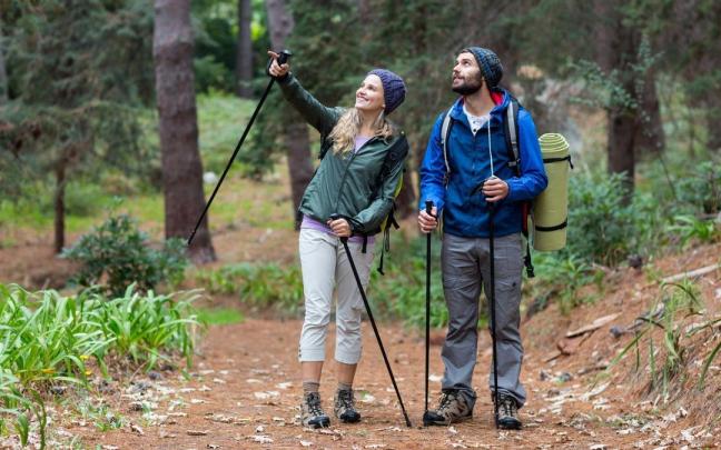 Una pareja disfruta de una caminata con bastones de trekking. Una pareja disfruta de una caminata con bastones de trekking.