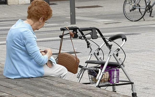Gasteizko erdiguneko banku batean eserita dagoen adineko emakume baten artxiboko-irudia. | ARGAZKIA: JOSU CHAVARRI