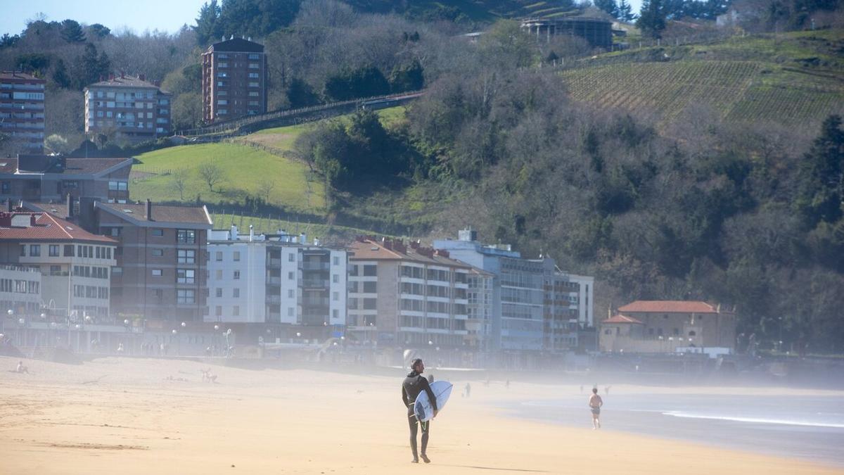 Un surfista disfruta del buen tiempo en la playa de Zarautz