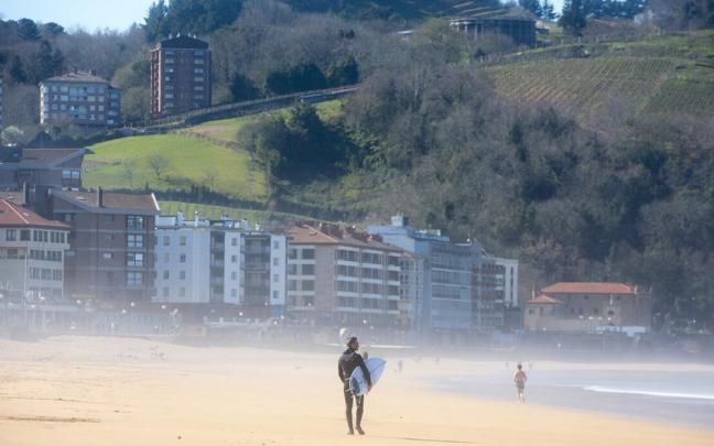 Un surfista disfruta del buen tiempo en la playa de Zarautz