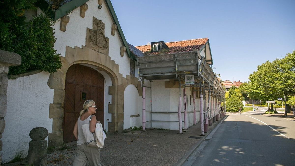 Un mujer pasa frente al portón de entrada de la finca de La Cumbre. permanentemente cerrado