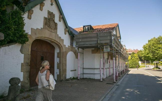 Un mujer pasa frente al portón de entrada de la finca de La Cumbre. permanentemente cerrado