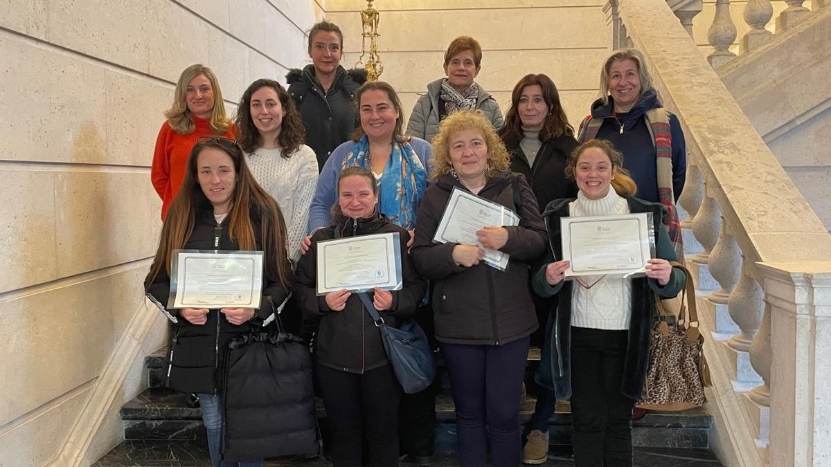 Varias participantes reciben un diploma tras hacer practicas en la Universidad de Navarra.