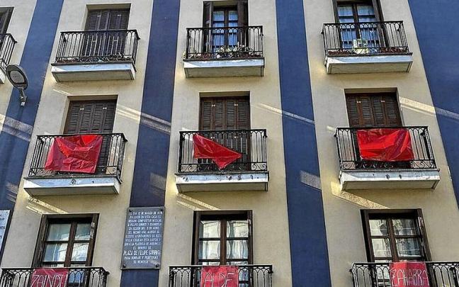Carteles rojos que están colocando en sus balcones los vecinos movilizados.