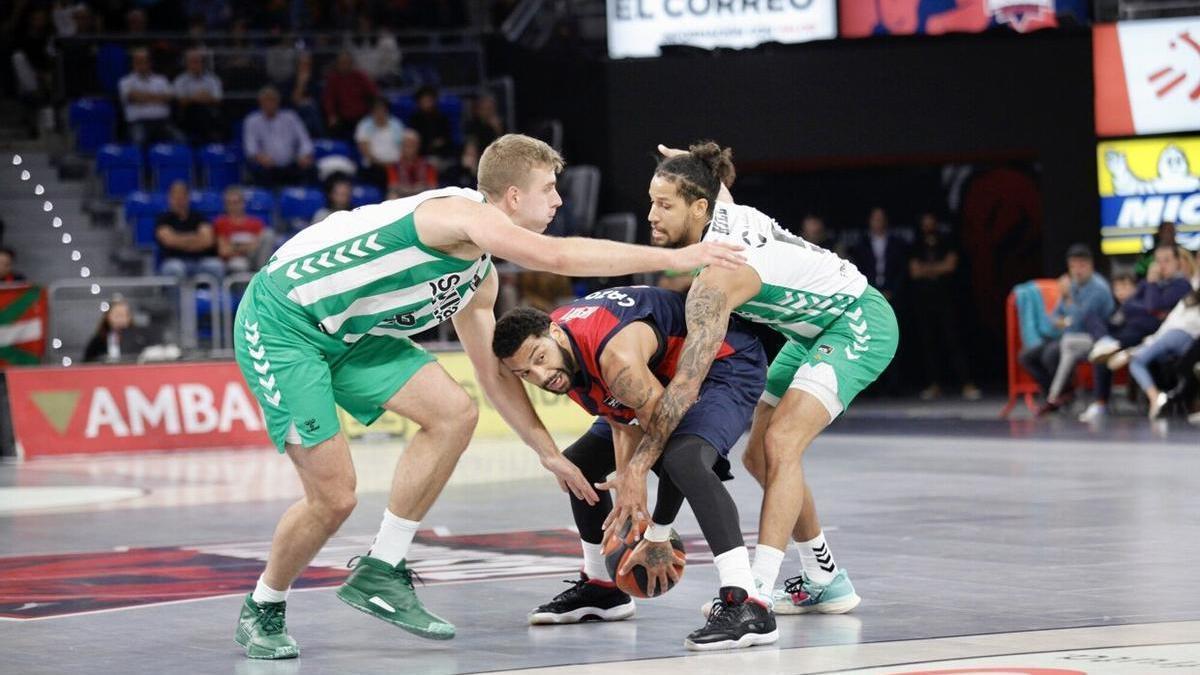 Henry, presionado por Gerun y Hill, protege el balón durante el duelo contra el Betis