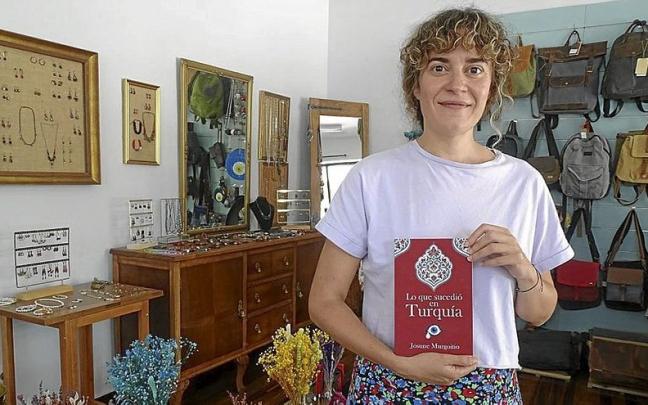 Josune Murgoitio mostrando su &uacute;ltima novela en su establecimiento Almila Shop, ubicado en Aretxabaleta.