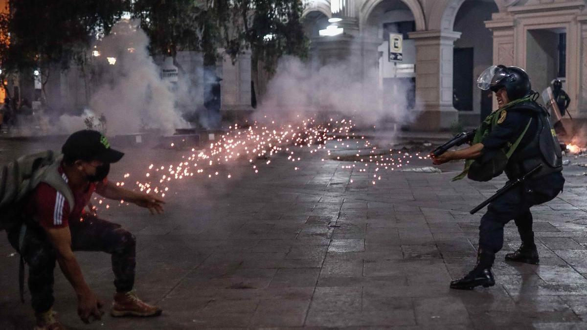 Un manifestante y un policía se enfrentan en las protestas en Lima.