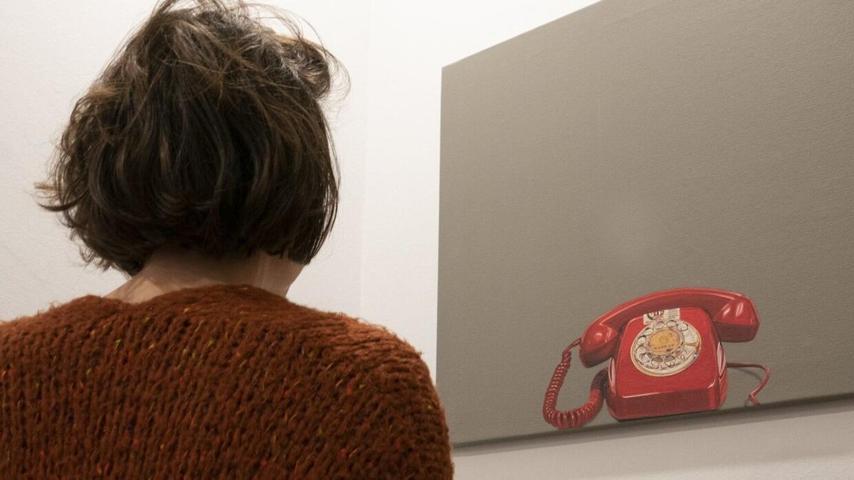 Una joven observa el teléfono impreso en un lienzo, en la sede donostiarra del Teléfono de la Esperanza de Gipuzkoa.