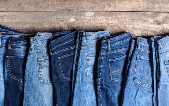 Pantalones vaqueros de distintos modelos sobre una superficie de madera.