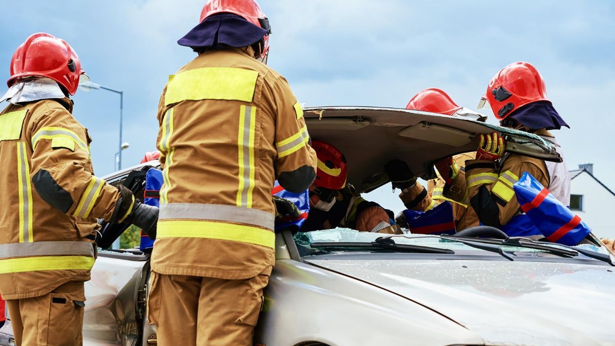 Miembros de un equipo de resctaes se afanan excarcelar a una víctima de un accidente de tráfico.