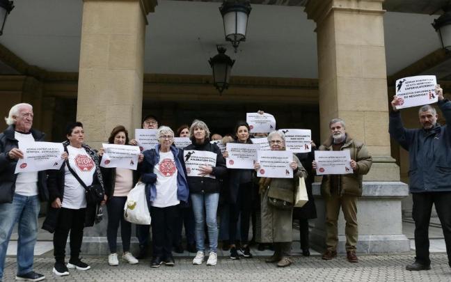 Los vecinos y vecinas del barrio donostiarra de Gros afectados por el Fondo de Inversión Azora, este mediodía, en la entrada del Ayuntamiento de Donostia.