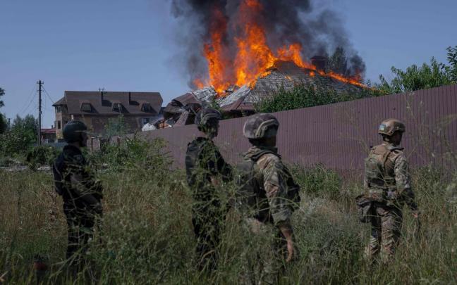 Soldados ucranianos frente a una casa ardiendo a las afueras de Bakhmut.