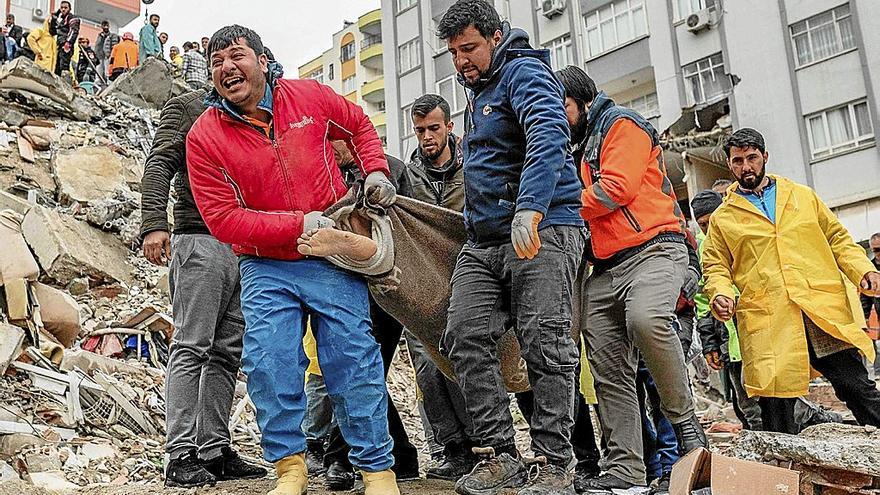 Un hombre lanza un grito desgarrador mientras acarrea un cuerpo sin vida sacado de los escombros en Adana. Foto Can EROK/Afp