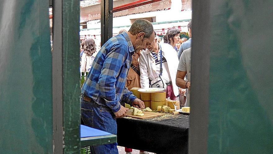 Un comerciante de queso, a mediodía, mientras atendía a varios clientes que hacían cola para degustar. | FOTO: MAIDER GOIKOETXEA