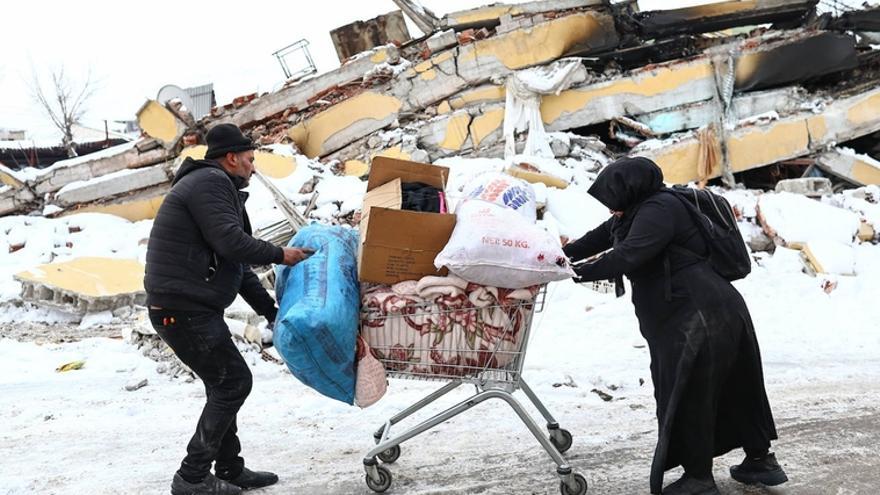 Una pareja arrastra sus pocas pertenencias tras el terremoto