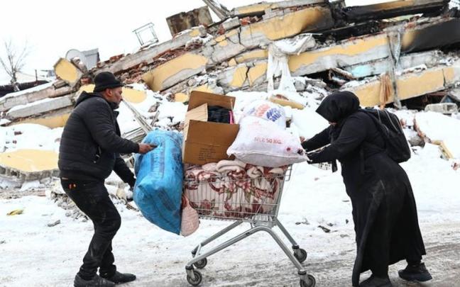 Una pareja arrastra sus pocas pertenencias tras el terremoto