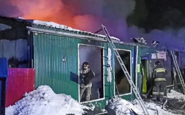 Bomberos en la residencia incendiada.