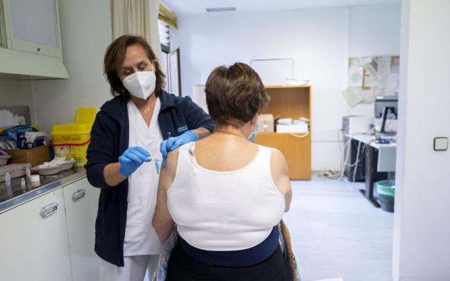 Una mujer recibe una vacuna contra la gripe. Una mujer recibe una vacuna contra la gripe.