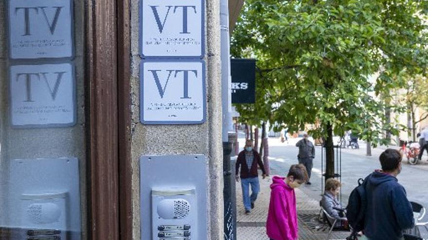 Un portal del Centro con dos placas anunciando la existencia de viviendas turísticas