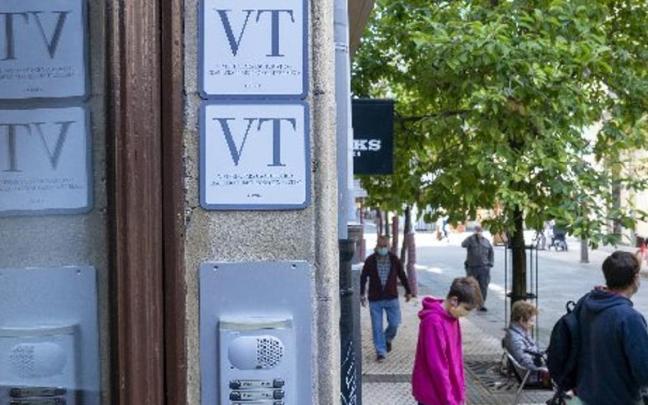 Un portal del Centro con dos placas anunciando la existencia de viviendas tur&iacute;sticas