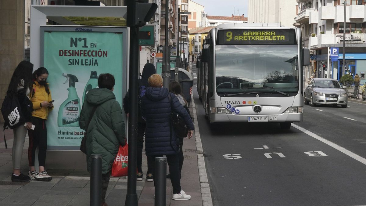 Varias personas esperan al autobus de la línea 9 en la calle Paz