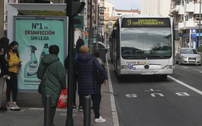 Varias personas esperan al autobus de la línea 9 en la calle Paz