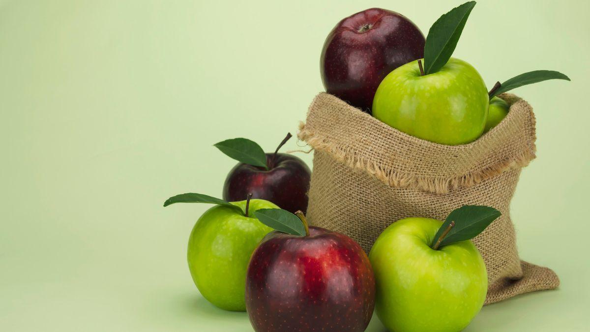 Manzanas de color rojo y verde en una cesta de tela.