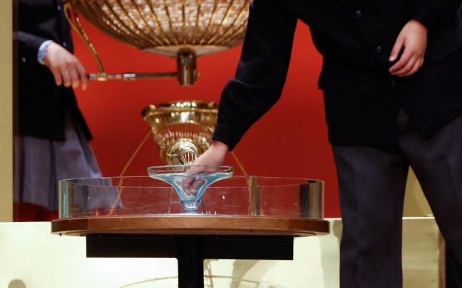 Un estudiante del colegio de San Ildefonso toma una bola de madera durante el sorteo de El Gordo de Navidad.