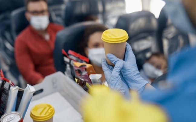 Una azafata, sirviendo un café a un pasajero en un avión. Una azafata, sirviendo un café a un pasajero en un avión.